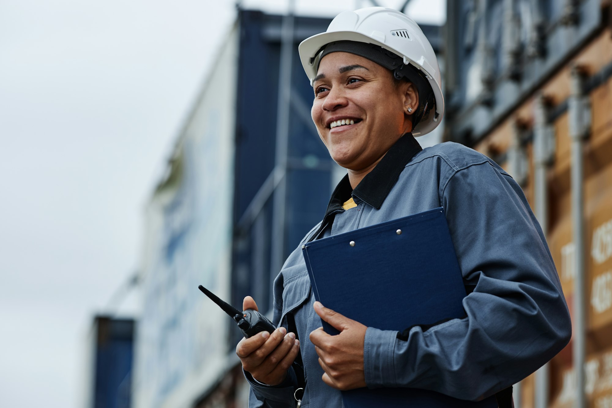 Woman working at shipping docks with containers