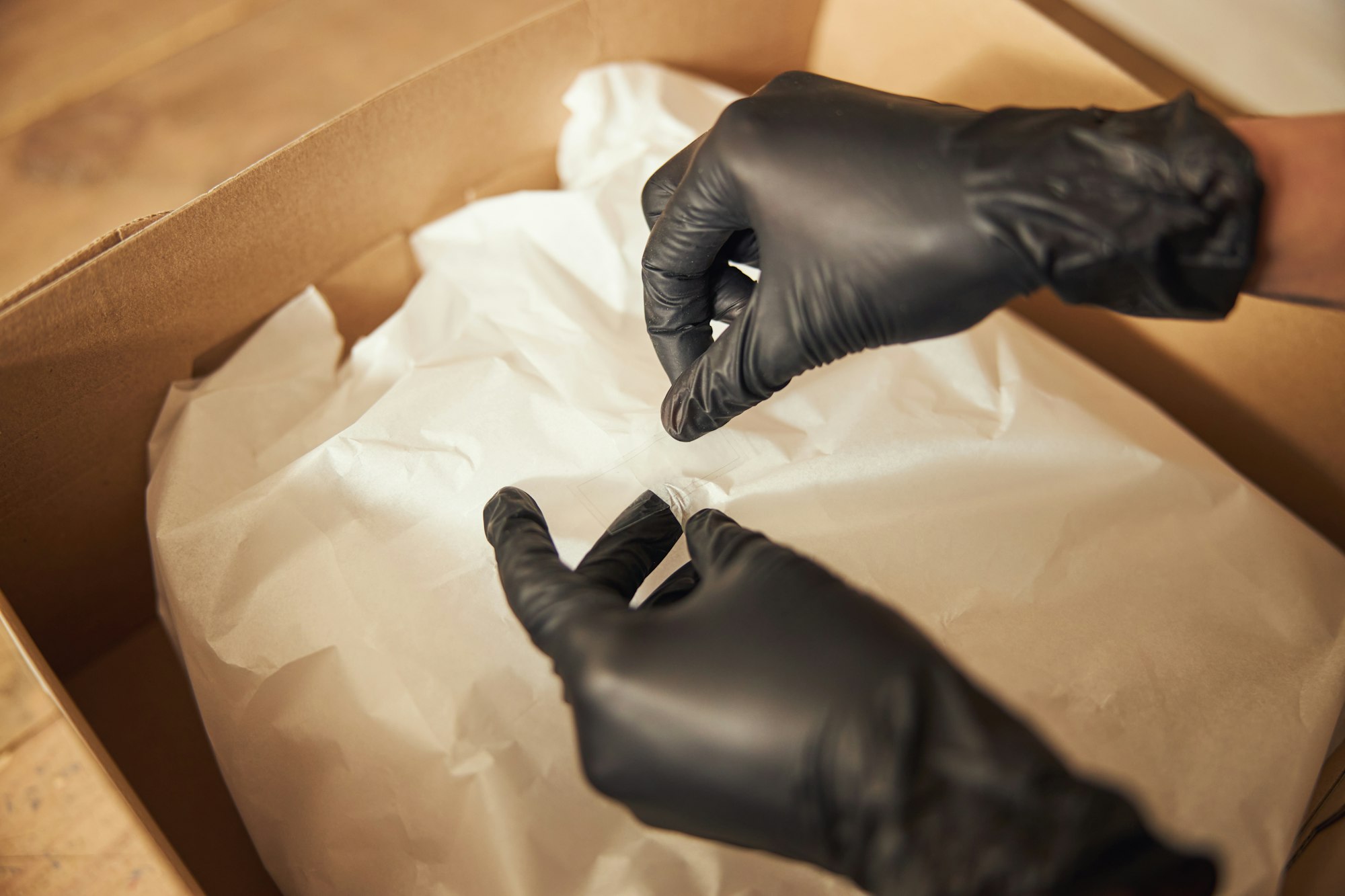 Worker in nitrile gloves preparing the package for shipping